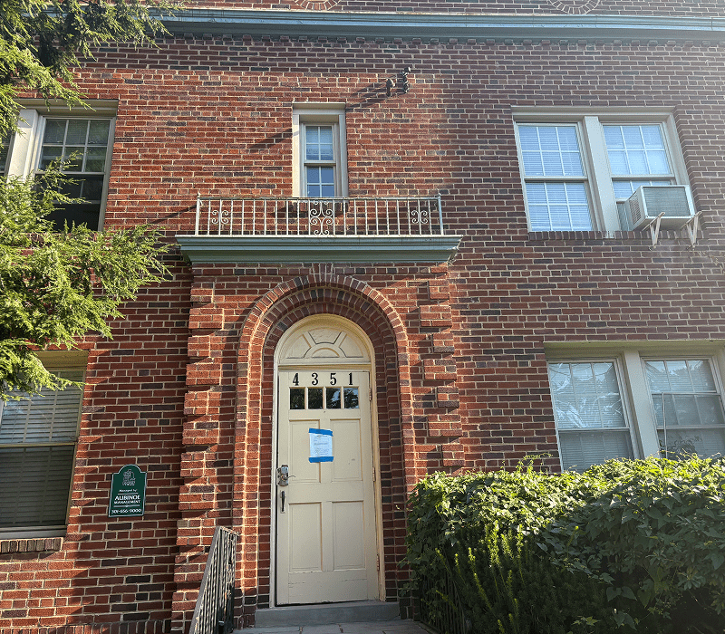 Red brick apartment entrance with arched doorway